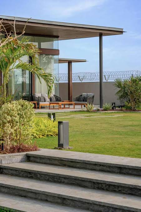 Modern glass pavilion overlooking a manicured lawn